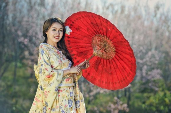 赤い和傘をさす着物の女性